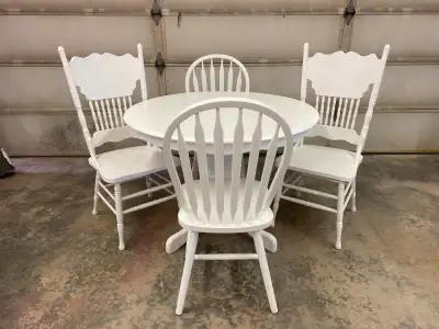 Solid wood dining room table with four chairs. Comes with extension leaf.