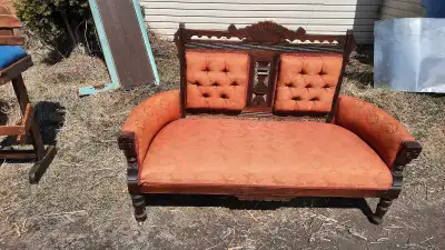 Découvrez cette causeuse victorienne ornée d'un tissu rouge distinctif et d'un cadre en bois sculpté...