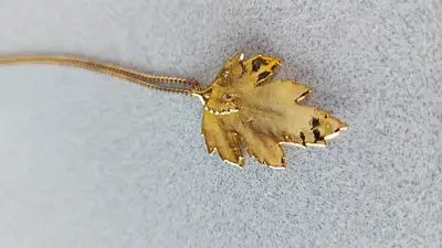 Gold plated maple leaf pendant. Length: 3 cm. Width: 2 cm.