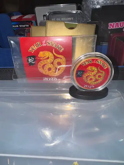 Selling a 2025 Year of the Snake Kennedy Half Dollar. The coin is gilded entirely in 24KT Gold and c...