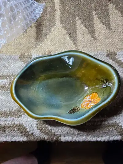 This is a vintage Wale Ireland trinket dish featuring a beautiful green glaze and a delicate flower...