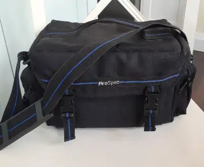 Made from black nylon with black and blue webbing handle, adjustable shoulder strap and trim. Secure...