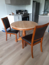 Table en erable avec deux chaises en bois et simili cuir noir,