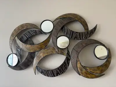 Add a touch of modern elegance to your home with this striking wall art mirror! The piece features a...
