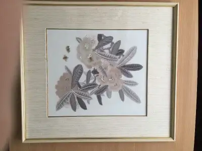 It is a beautifully embroidered picture of flowers and bees nicely framed and under a glass cover, a...