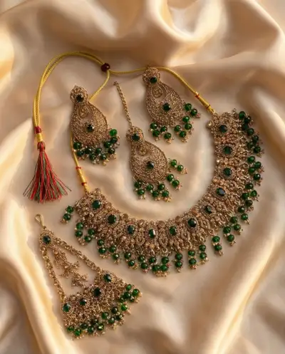 Adorn yourself with this stunning jewellery set, featuring a necklace, earrings, maang tikka and pas...
