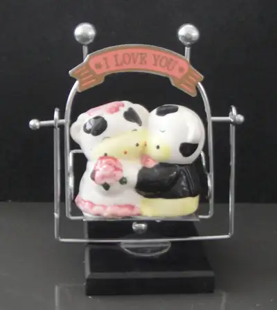 Pair of handmade Ceramic Hugging Cows lover sitting in the swing, View more