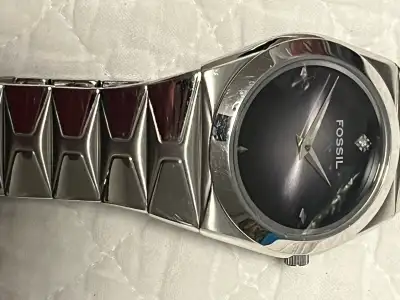 This elegant used Fossil watch features a sleek silver band and a sophisticated dark face, making it...