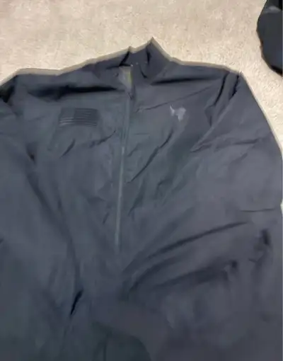 This pre-owned Under Armour Project Rock USA jacket in size XL is a high-performance piece perfect f...