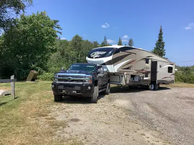 A very cozy 1 bedroom camper with full size living room with a brown leather pull out bed couch, and...
