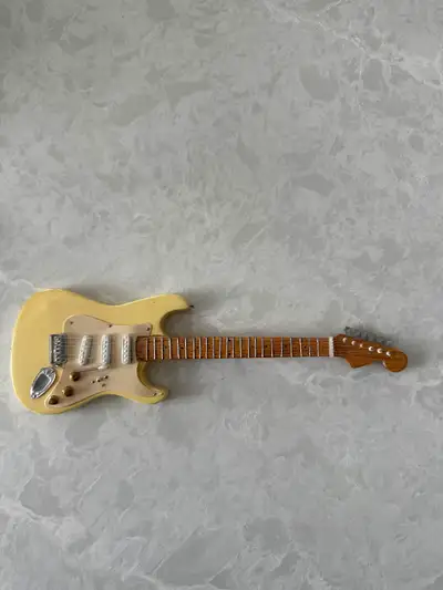 Miniature replica of a Fender Stratocaster electric guitar., View more