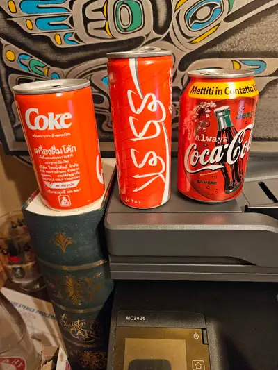 I have a set of three Coca-Cola collectible cans in good condition, featuring unique designs and int...
