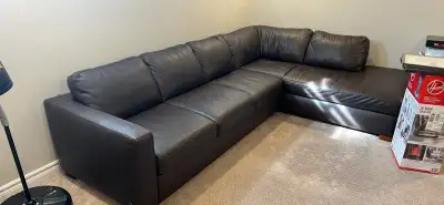 This is a dark brown Natuzzi Editions leather sectional sofa, perfect for a living room or family ro...