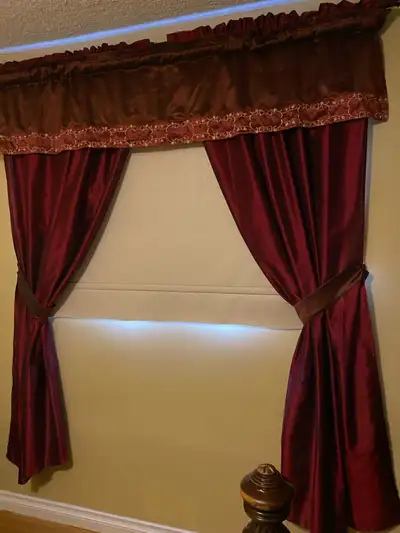 Enhance your home decor with this set of burgundy window curtains, complete with a matching valance,...