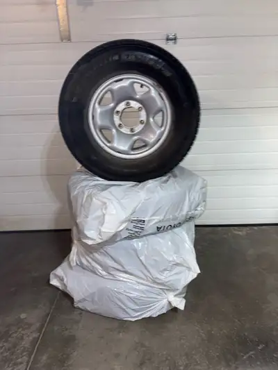 265/70R/R16 Michelin X-ICE Snow SUV winter tires with rims from a Toyota Tacoma.
