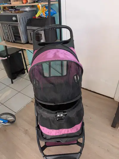 Poussette pour chiens achetée chez dyno servie environ un mois Couleur rose,se plie très facilement...