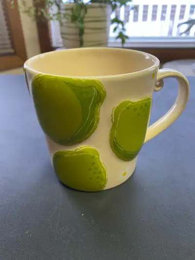 - Cream-coloured Starbucks mug, featuring a raised limes and daisies design - Issued in 2006 - Used,...