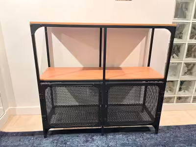 Shelving unit with wood tops, black metal framing and a storage area enclosed by mesh doors. It woul...