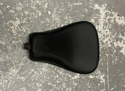 This is a used seat from a Harley Davidson XL1200X motorcycle, offering a stock, low-profile riding...