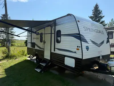 Front queen bed, small slide with dinette that converts to bed, twin bunks in the rear, separate bat...