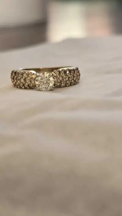 14KT Yellow Gold 1 Centre Round Diamond. Approx weight .57 CT The band is a pave set with a total of...