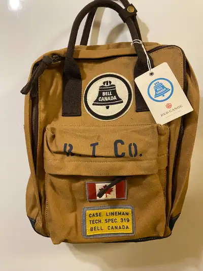 New with Tags Red Canoe Backpack Retro Bell Canada Logo. This is made of nylon, Tan colour, has fron...