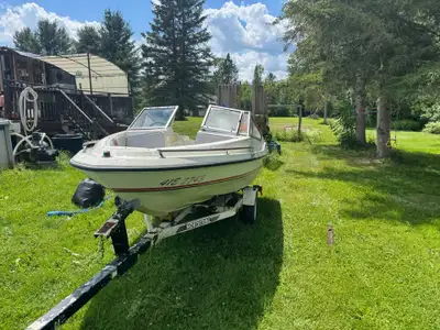 Classic Sunray bowrider boat has a white fiberglass hull with red and black accents. It is equipped...