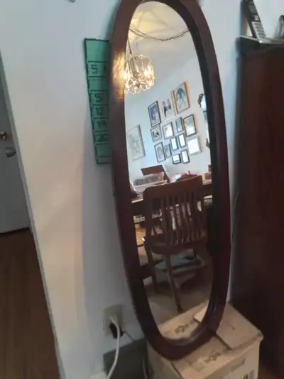 Dark walnut colored wooden framed oval mirror. Meant to be hung on wall 46x16 1/2". Frame is 2" wide...