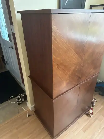 Dark brown wood entertainment center. Two cabinets with doors, interior shelving, and a pull-out key...