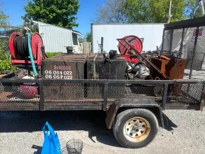 For sale is asprayer trailer, equipped with hose reels and a tank, showing signs of wear from previo...
