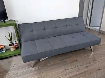 This stylish grey futon is perfect for adding extra seating and sleeping space to any room. As a fut...