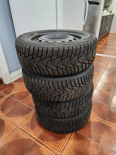 Set of winter tires and rims. Tires have a tread pattern. Rims are a dark grey colour. Perfect for t...