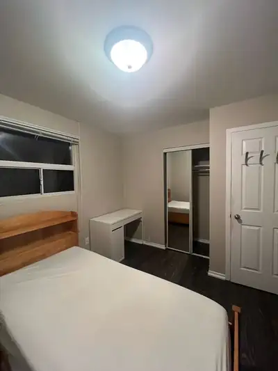 Spacious, clean, fully furnished private room with bed, desks, chairs, mirror closet, and a large wi...