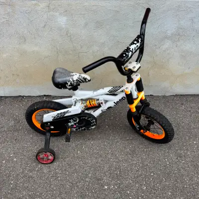 Cool white Jeep children’s bike with training wheels, perfect for beginners! Features rugged black/o...