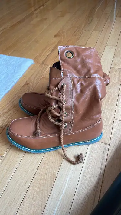 Brown boots Round toe with flat sole Pull up style with lace up front Signs of wear near the eyelets...