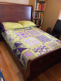 Full size sleigh bed with box spring and matching nightstand.