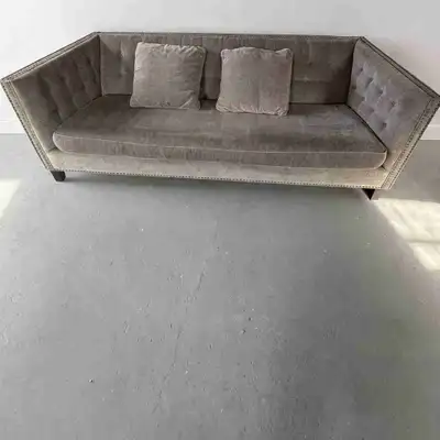 Stylish grey tufted sofa with nailhead trim and angled arms. Bench cushion + 2 matching down feather...