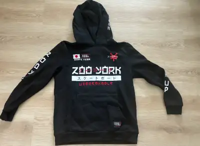 This pre-owned Zoo York youth hoodie features a bold Japanese-inspired design with key graphics on t...