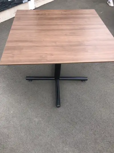 This square table features a sleek, modern design with a wood-grain top and a sturdy black metal bas...