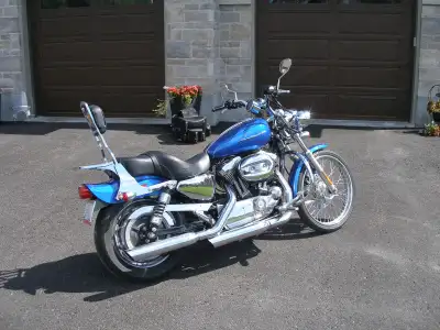 This 2007 Harley Davidson XL1200C is a well-maintained, pre-owned cruiser featuring a striking blue...