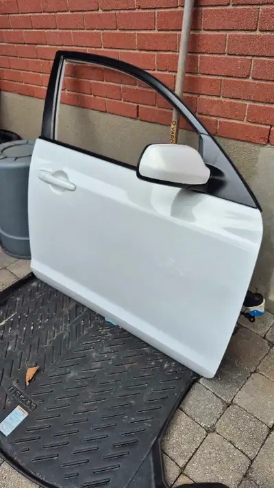This is a used first gen (2004-2009) Mazda 3 front passenger door, complete with the heated power si...