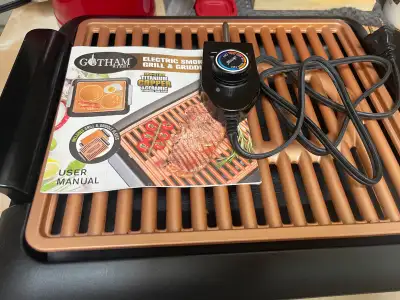 This pre-owned Gotham Steel Electric Smoke-less Grill & Griddle is a versatile kitchen essential tha...