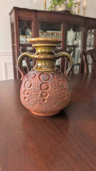 Unique West German pottery vase. Features two handles, textured body, and a brown and green glaze. N...