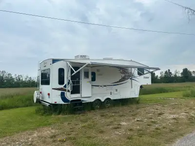 27RL fifth wheel. Great couples trailer. Two swivel chairs at the back. Table and chairs. Electric J...