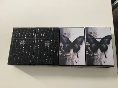 Selling four new cigarette cases. They hold a 20 pack. Price is 5.00 each. Two black and two butterf...
