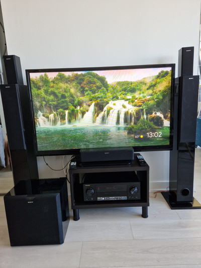LG TV and a TV Stand, AV Receiver, 5 Speakers, Subwoofer.