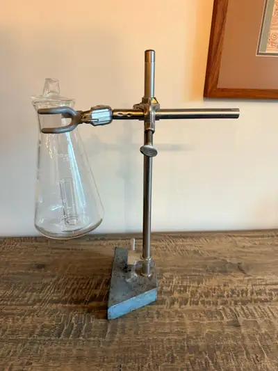 Vintage PYREX laboratory filtering flask mounted on an adjustable laboratory stand with clamp. Authe...
