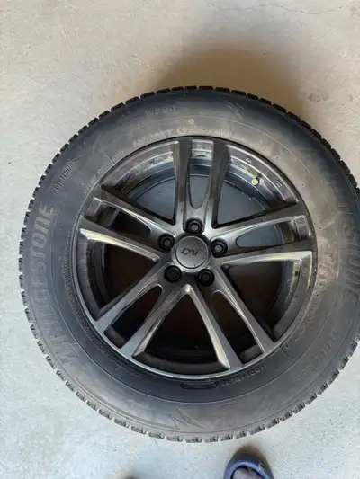 These Bridgestone Blizzak WS90 winter tires in size 225/65R17 come pre-mounted on aftermarket rims,...