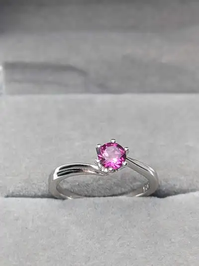 A vibrant .50 carat raspberry‑pink rhodolite garnet set in solid 925 sterling silver. The gemstone s...