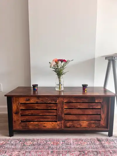 Two matching wood cabinets with sliding doors. Each cabinet has two compartments with slating on the...